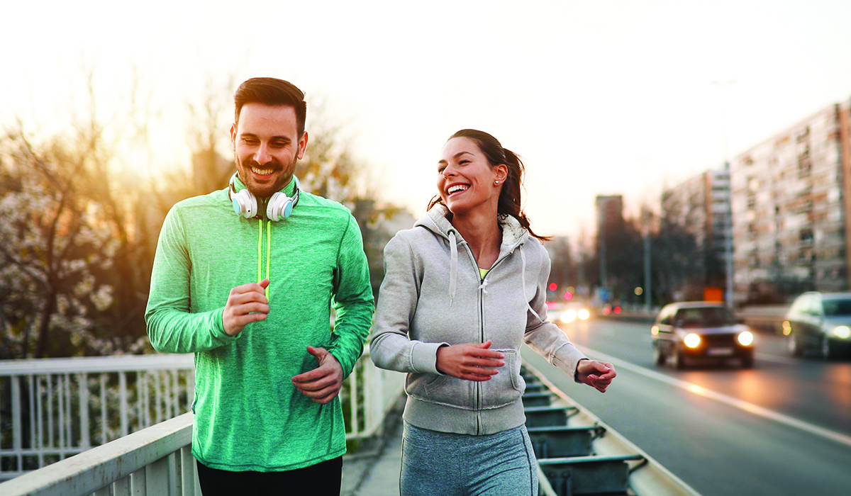 man and woman jogging outdoors in city